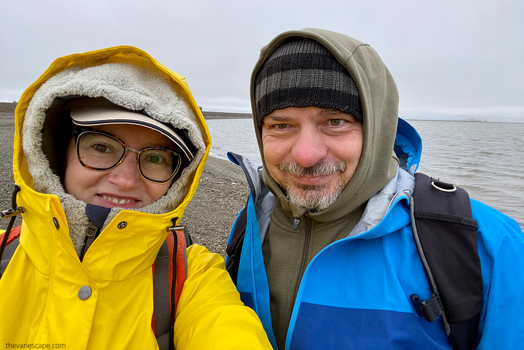 Agnes and Chris in waterproof raincoats on Dalton Higway at the Arctic Ocean.