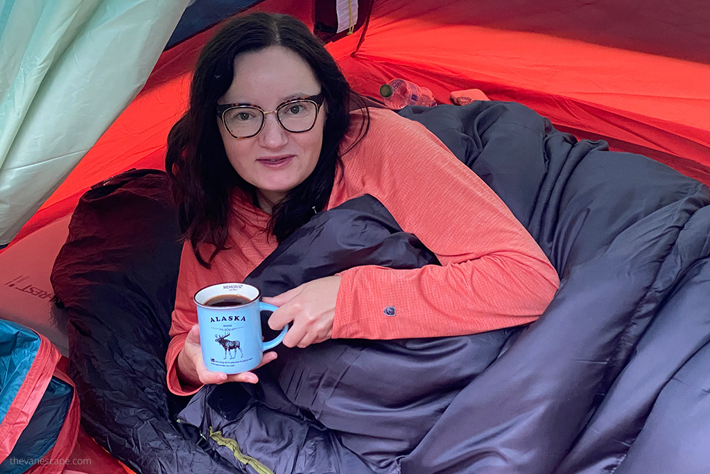 Agnes drinking coffe inn a tent.