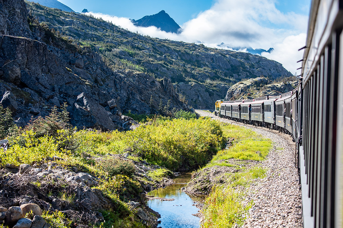 Scenic train raide in Skagway Alaska - view of train and mountains.