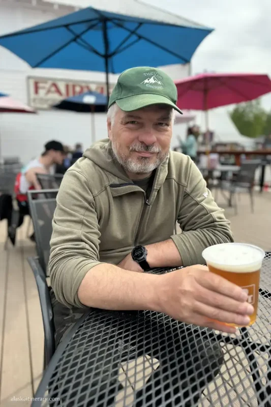 Chris drinking a beer in Talkeetna in the summer garden in Fairview Inn Hotel.