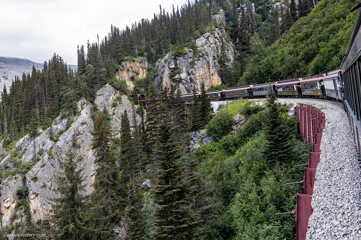 White Pass & Yukon Route - train entering the tunnel in mountains.