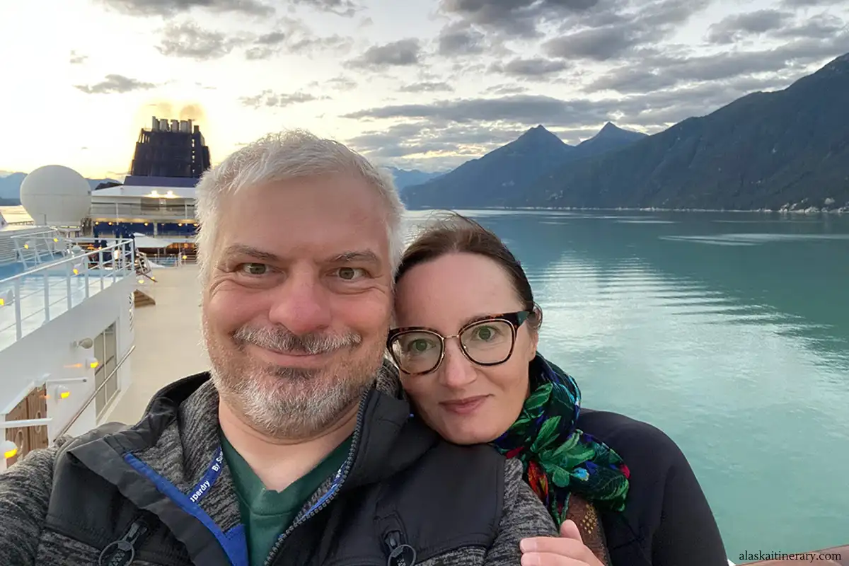 Agnes and Chris on cruise ship to Alaska with mountains in backdrop.