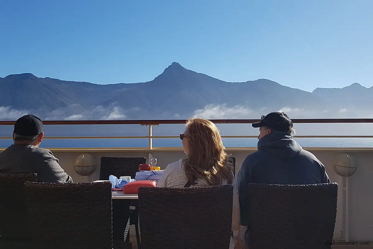 Alaska cruise review - people admiring mountains from Norwegian cruise ship.