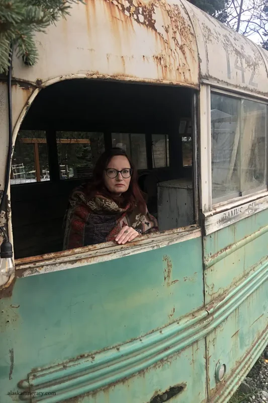 Agnes sitting in the replica of Magic Bus 142 in Healy from the movie Into the wild.