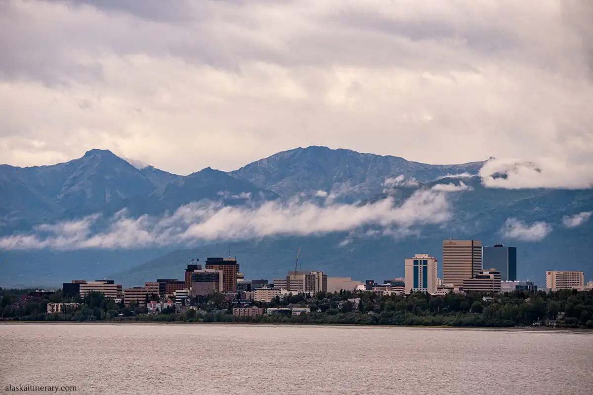 City skyline of Anchorage before sunset with stunning mountains in the backdrop.