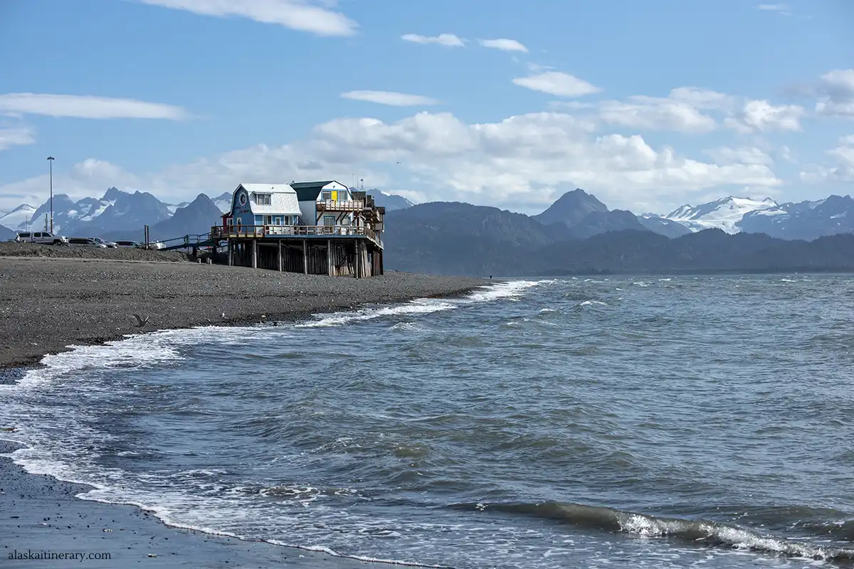 Scenic view of Homer with wooden houses, blue sea and mountains and glaciers in the backdrop.