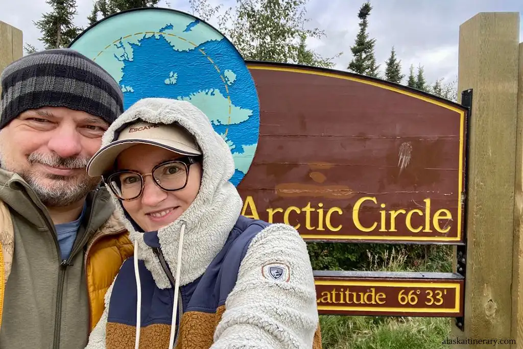 Agnes Stabinska, the author, with her partner Chris next to the Arctic Circle sign during trip from Fairbanks.