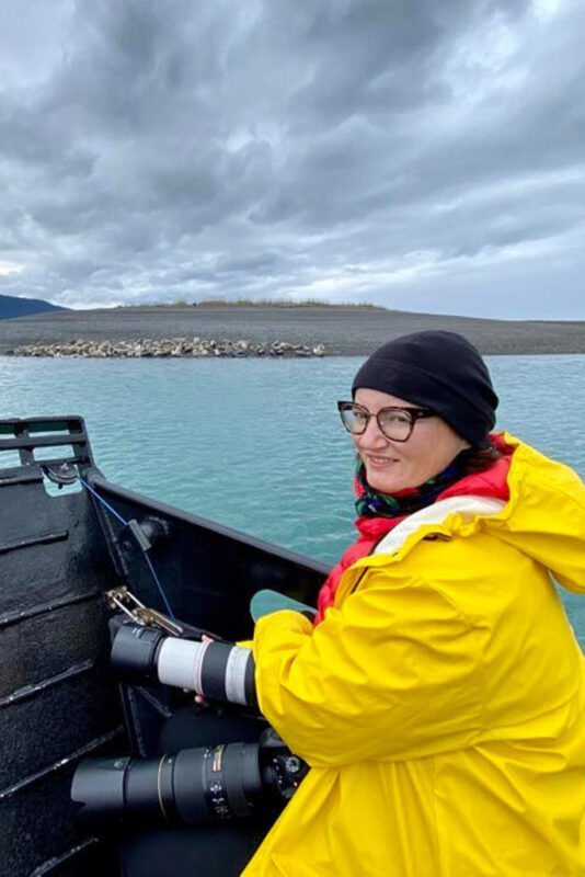 Agnes Stabinska, the author, with her camera taking pictures of sea lions basking on rocks during our Katchemak Bay wildlife tour by boat from Homer.