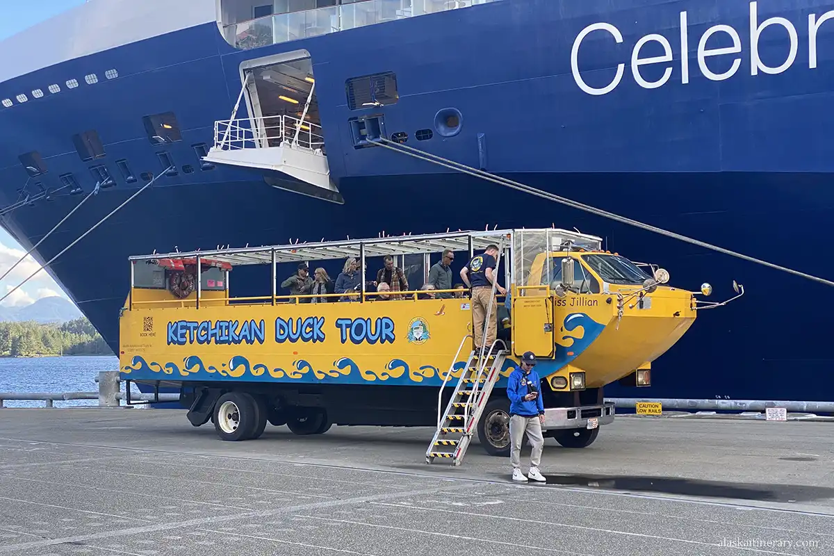 A yellow vehicle of Ketchikan Duck Tour against the background of a large cruise ship.