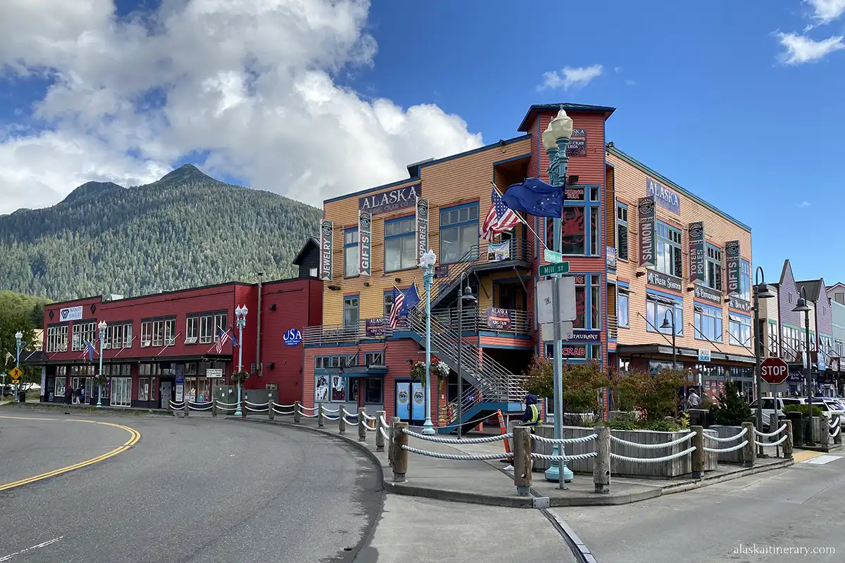 Beautiful wooden colorful architecture of Ketchikan, restaurant and shop buildings in the background with green mountains.