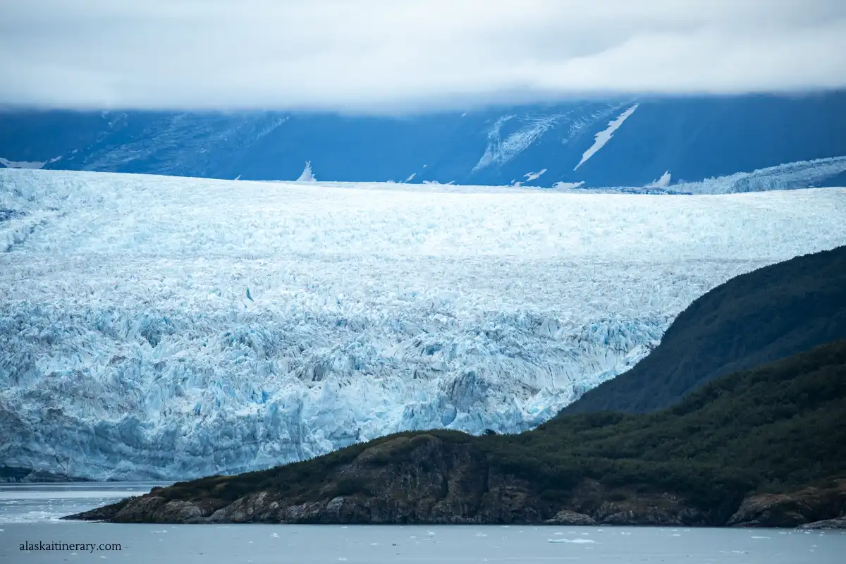 Huge Hummard Glacer: huge coast of iceberg and side of rock with trees.