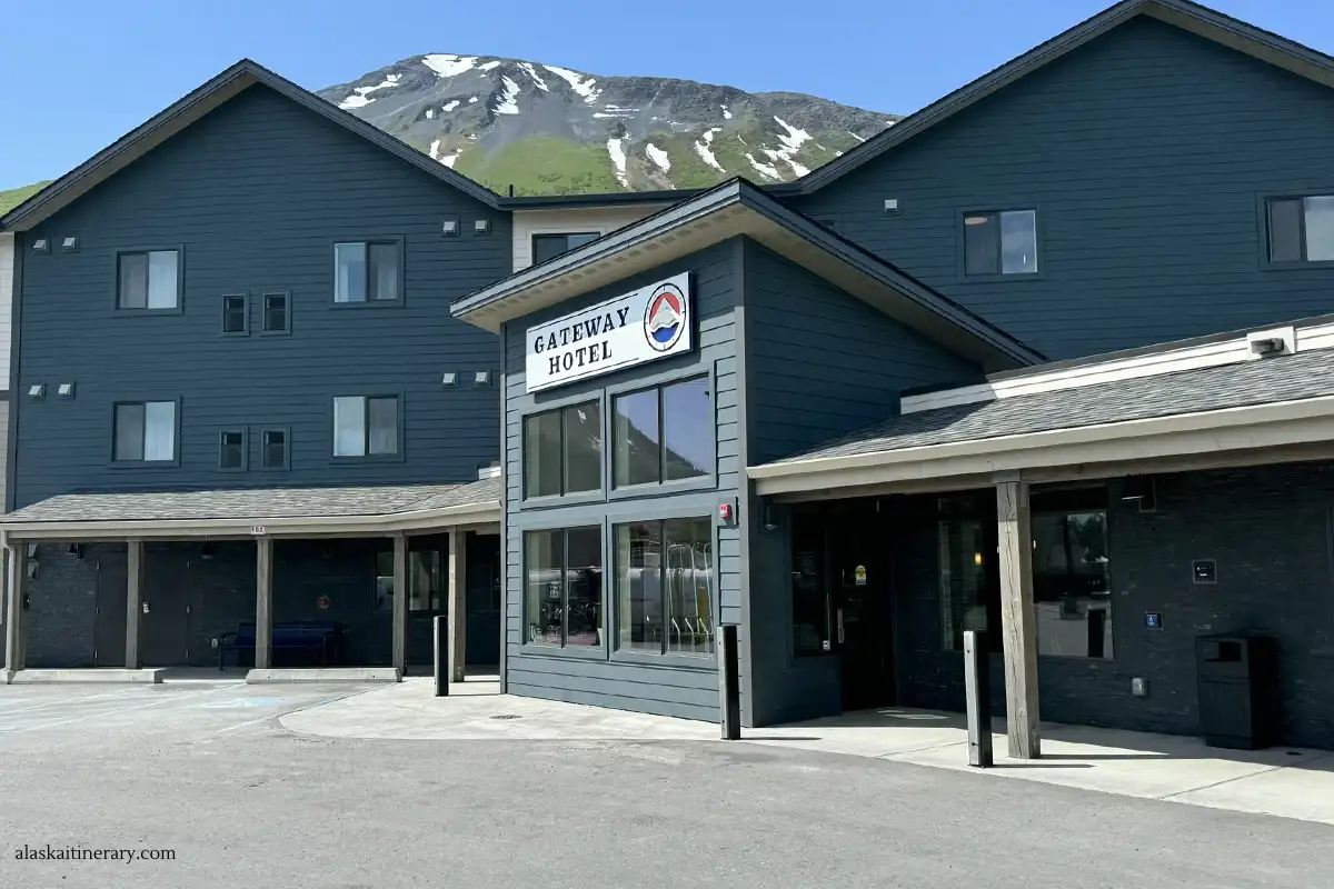 Main entrance to Gateway Hotel in Seward with mountains in the backdrop.