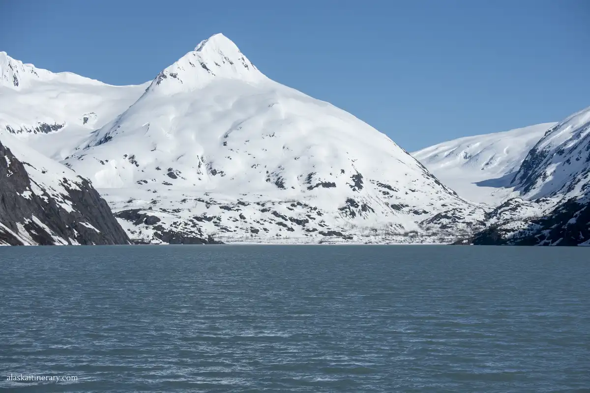 Blue water of the Portage Lake surronded by mountains covered by fresh white snow.
