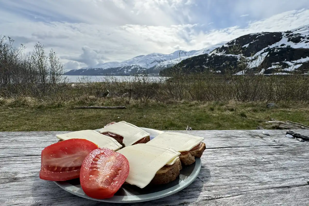 camping in Whittier: sandwiches and tomatos at the picnic table with the mountain and bay view.