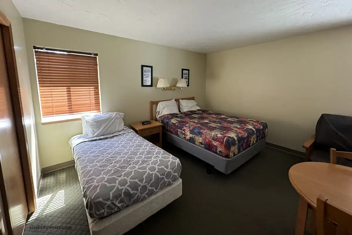 Two beds and table in our spacious room in budget-friendly Murphys Alaskan Inn.