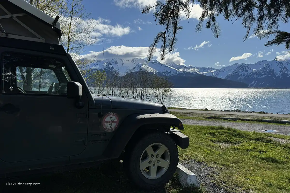 Jeep with a rooftop tent at the campground with the sea view.