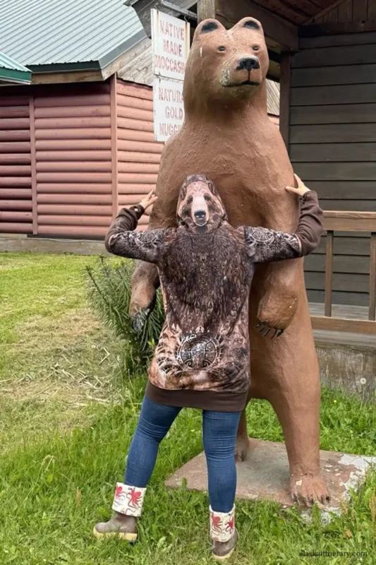 Agnes Stabinska, the author, in downtown Haines with the wooden bear statue.