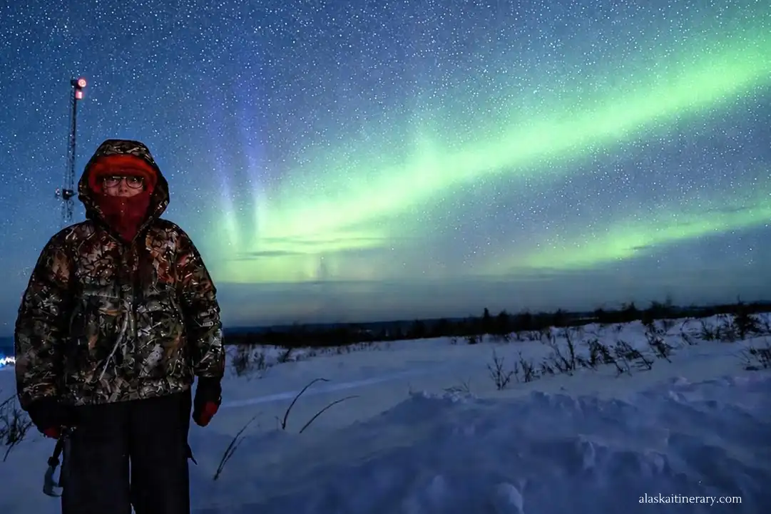 Agnes Stabinska, the author, with aurora borealis in the backdrop at Murphy Dome in Fairbanks area.