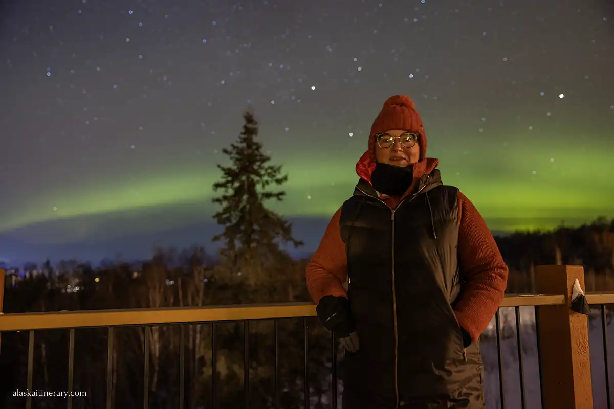 Agnes Stabinska, the author, with the northern lights in the backdrop in Alaska in winter.