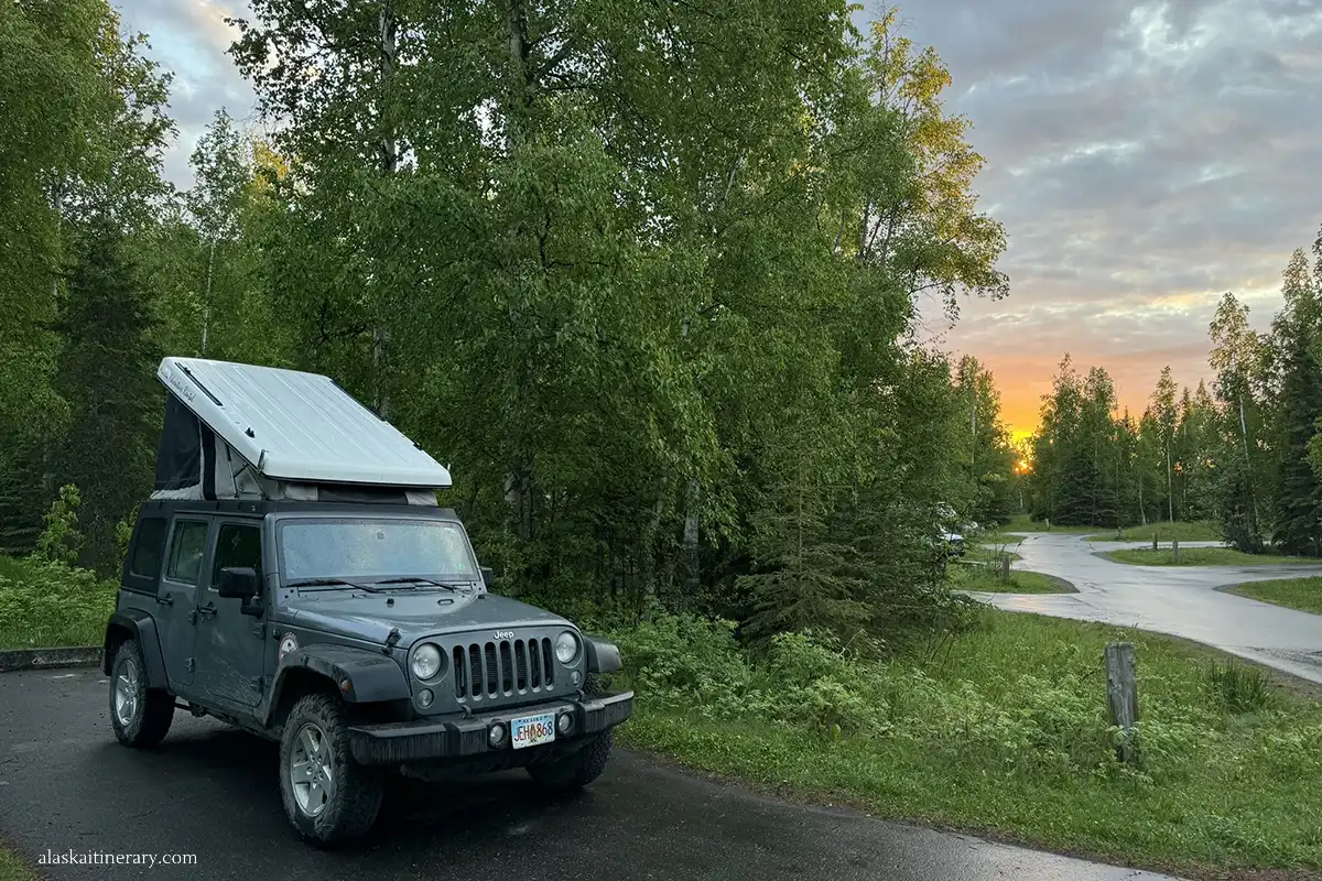 Jepp Wrangler with a roof-top tent during sunset on the camping.