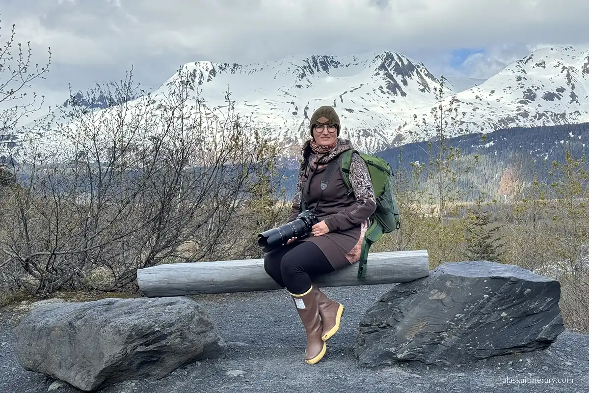 Agnes Stabinska, the author, is sitting on a bench with a mountain view in the Exit Glacier hiking trails area.
