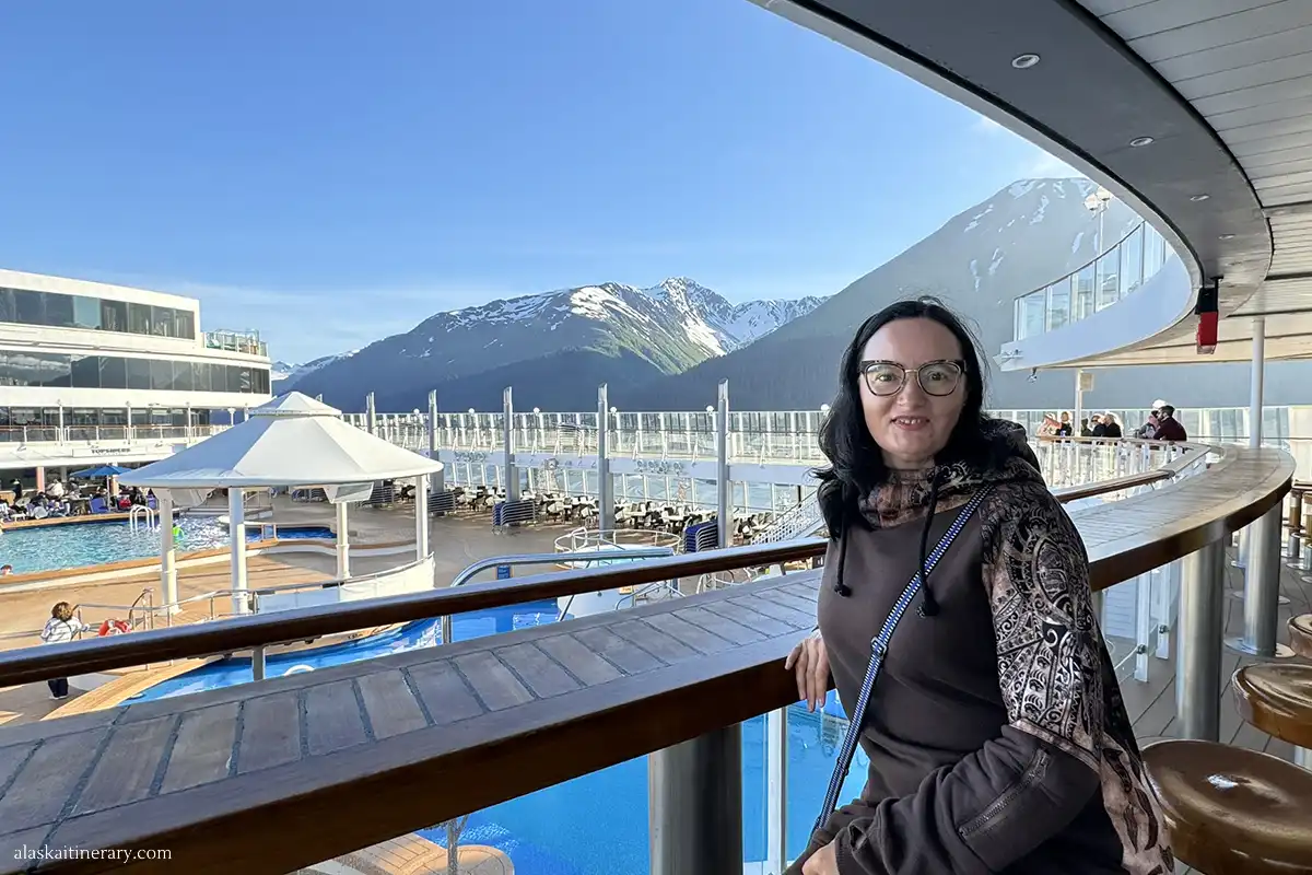 Agnes Stabinska, the author, on Norwegian cruise ship in Seward, with stunning mountains views in the backdrop.