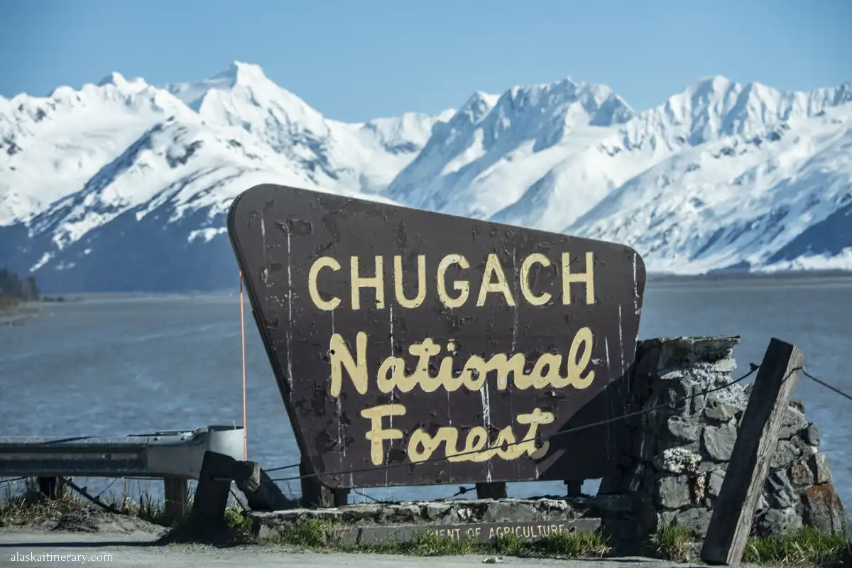 Chugach National Forest wooden sign with mountains in the backdrop.