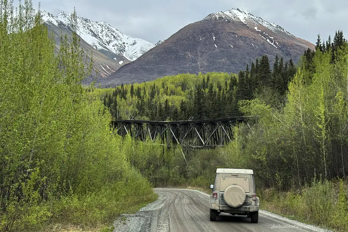 Our rented jeep wrangler on the McCarthy road with the wooden old bridge in the backdrop.