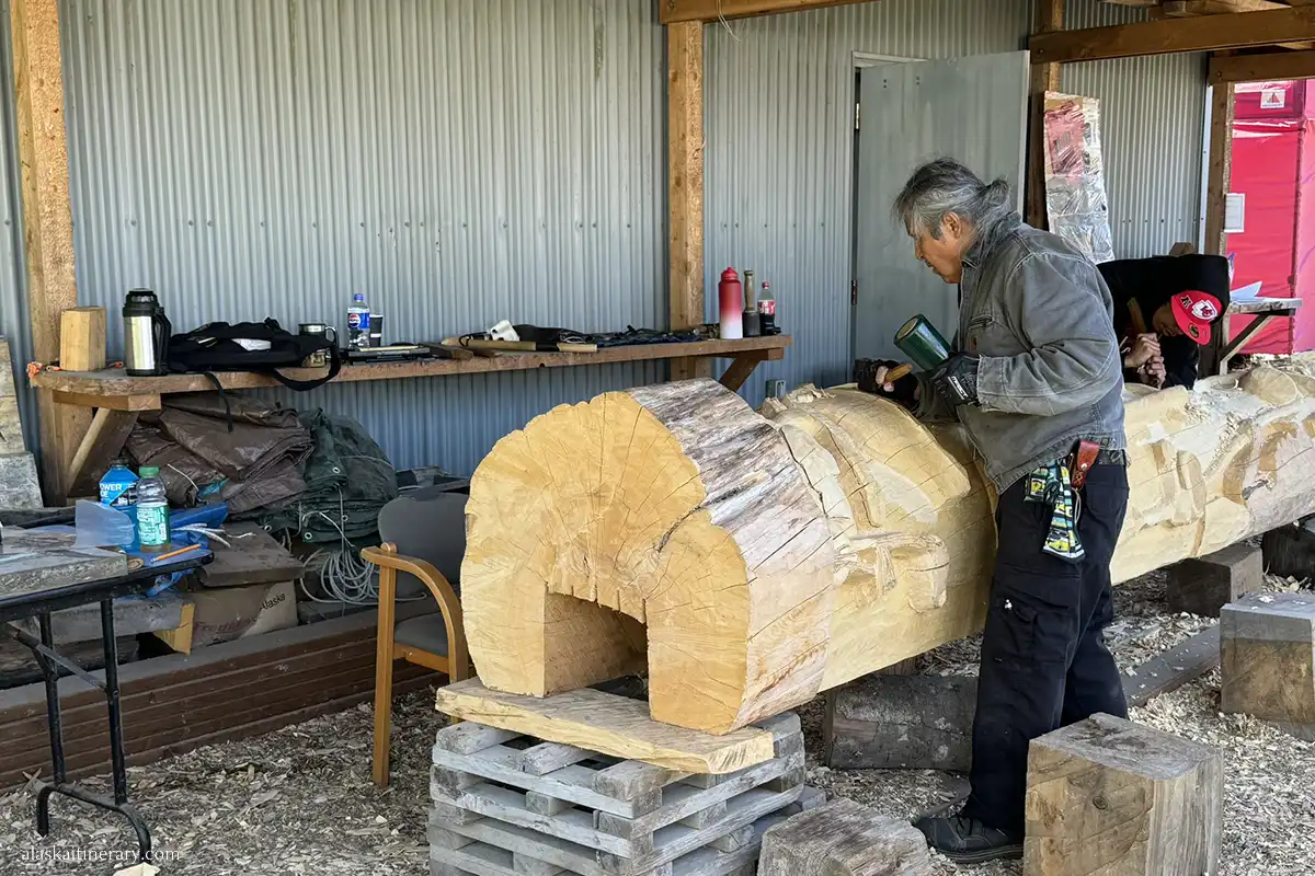 Local articst in Hoonah is carving totem pole.