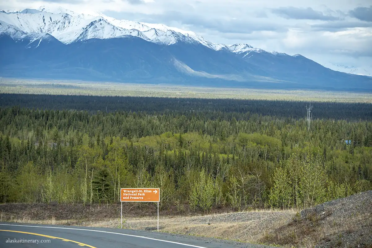 Wrnagel Mountains and road sign posting the entrance to Wrangell St.Elias National Park from Nabesna Road.