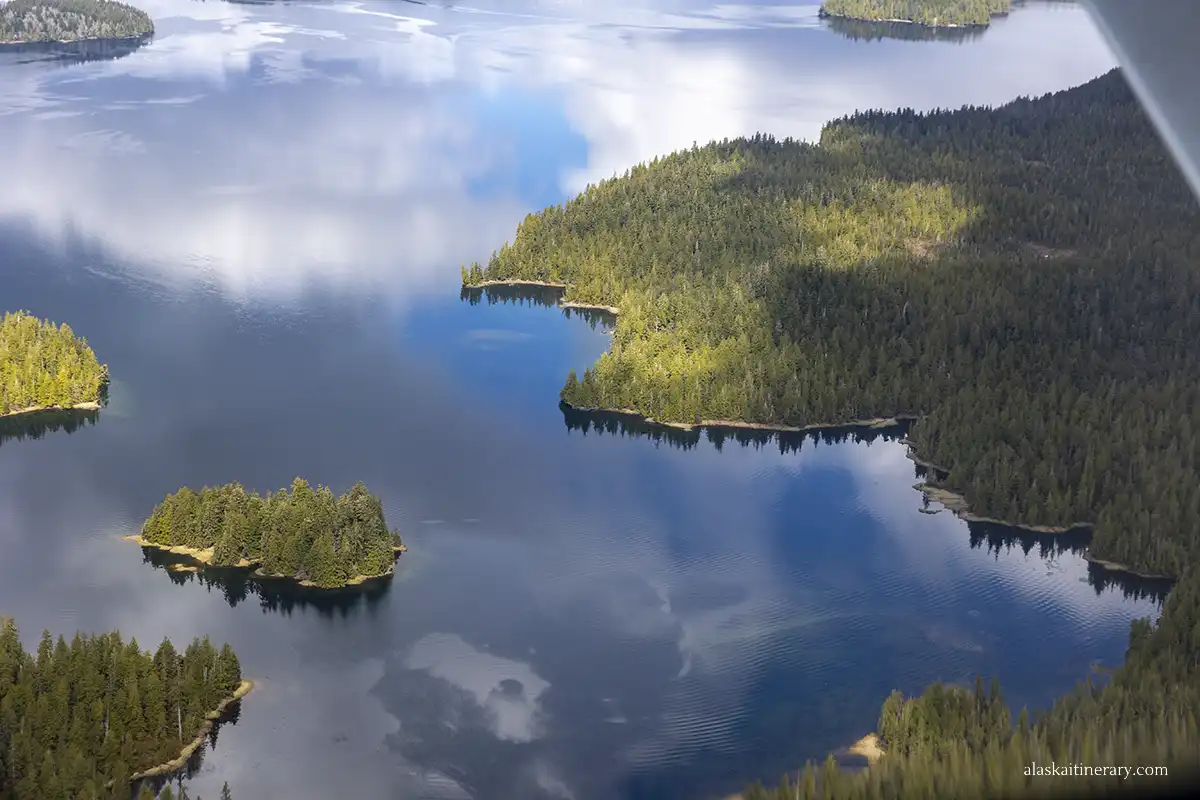 Deep blue water and small islands covered by green trees - the view from seaplane.