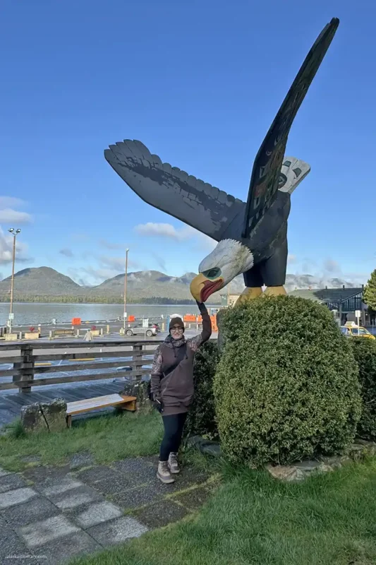 Agnes Stabinska, the author, next to the wooden bold eagle totem in Ketchikan.