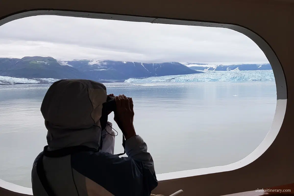 Looking at glacier through binoculars on Alaska cruise ship.