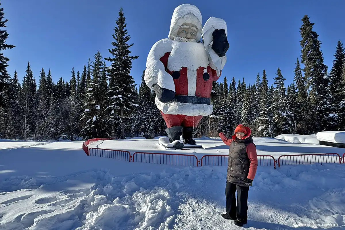 Agnes Stabinska, the author, next to huge statue of Santa Claus in North Pole in winter.