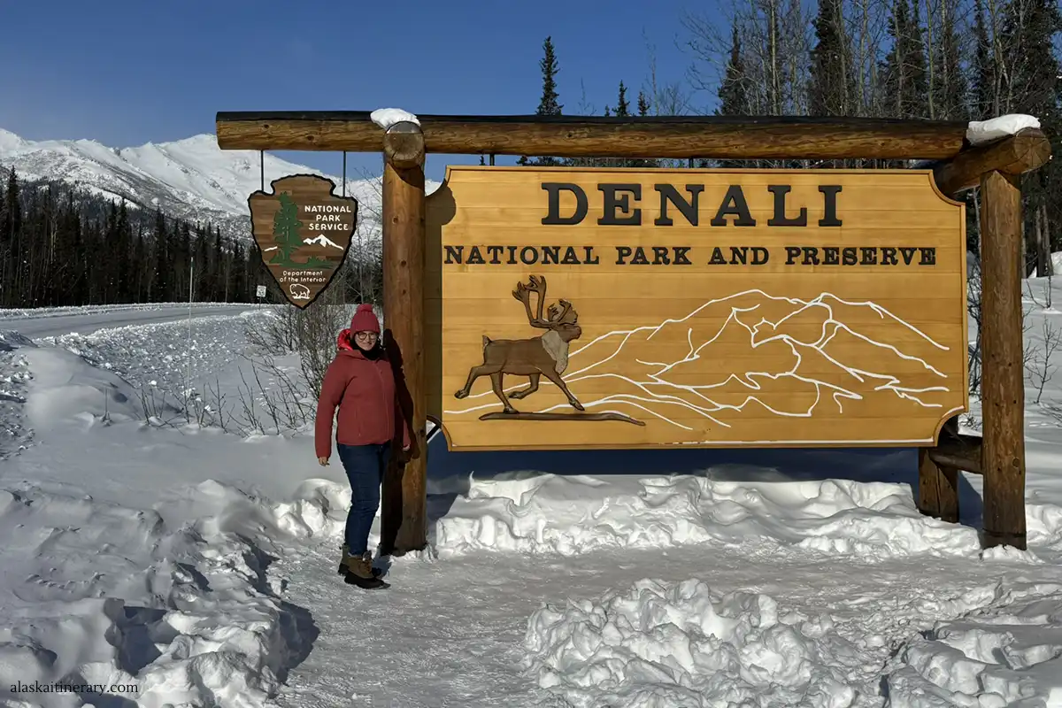 Agnes Stabinska, the author, next to the sign: Denali National Park and Preserve in winter scenery.