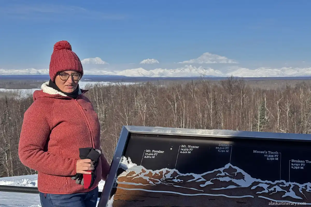 Agnes Stabinska, the author, with Alaska Range view and Denali peak from tarrace of Talkeetna Alaskan Lodge.